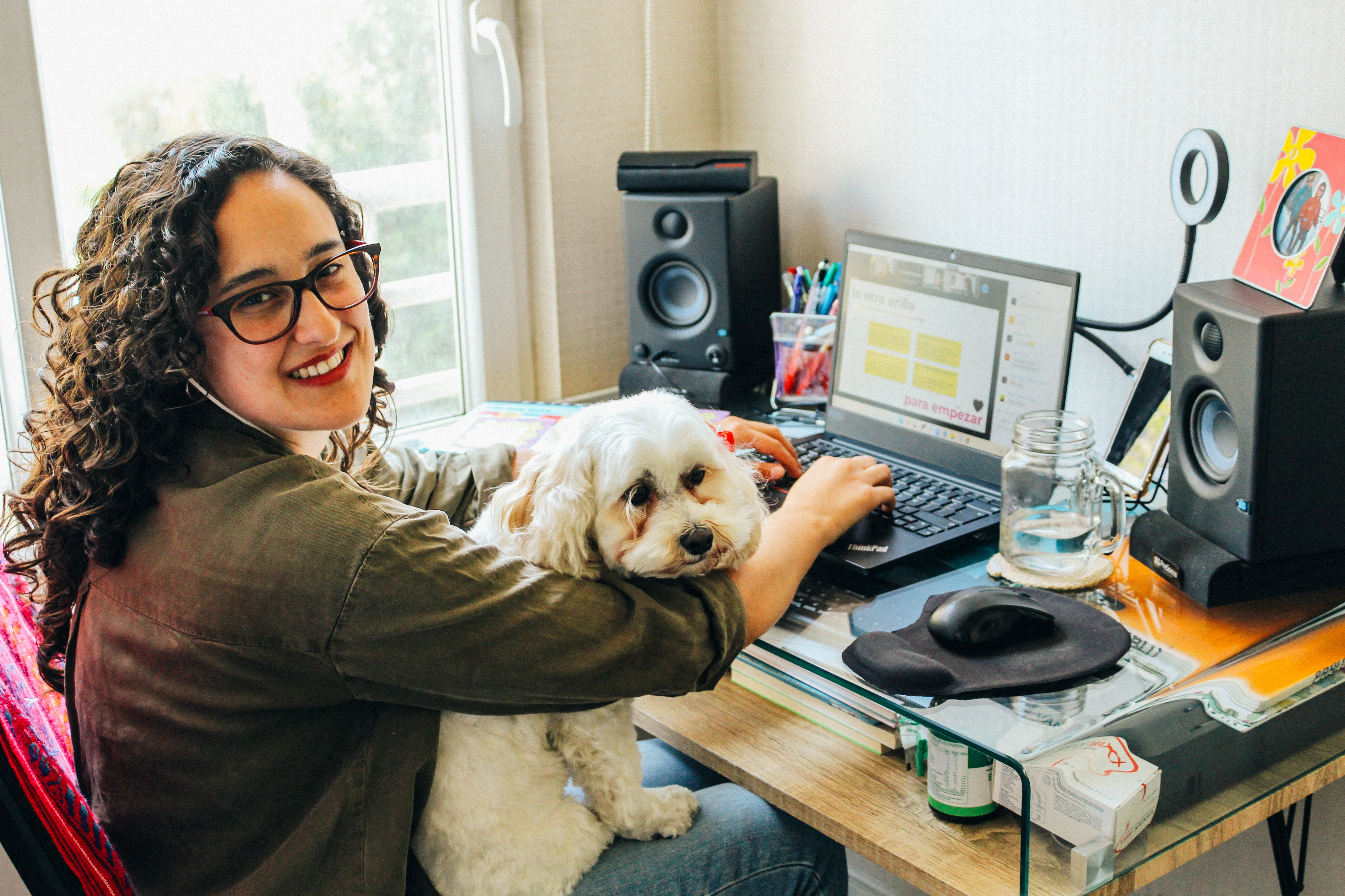 mujer estudiando diseño ux mira a la cámara con perro en regazo